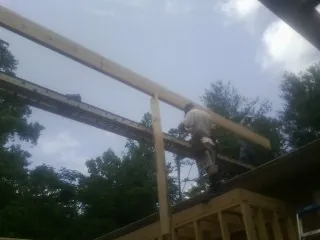 Carpenter setting a ridge beam over a new addition frame — Ice Dam Removal by Roofing Brothers in Livingston Manor
