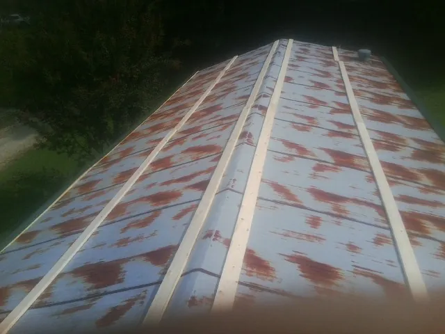 Rusted metal roof panels with new wood purlins before replacement — Storm Damage Roof Repair in Livingston Manor by Roofing Brothers