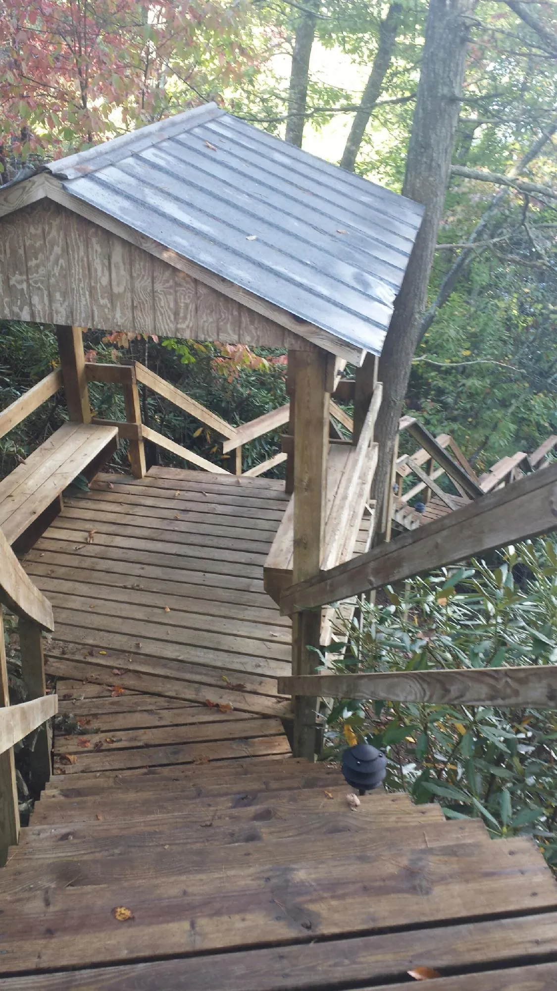 Metal roofed shelter over wooden steps on a wooded walkway — Skylight Repair & Installation work by our crew in Livingston Manor
