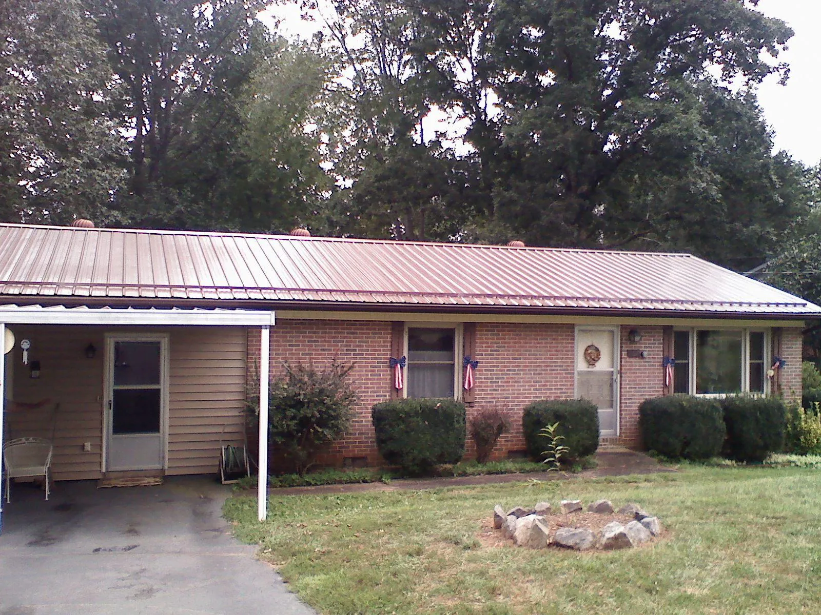 Bronze metal roof and carport on a brick ranch home — Roof Repair work by our crew in Livingston Manor